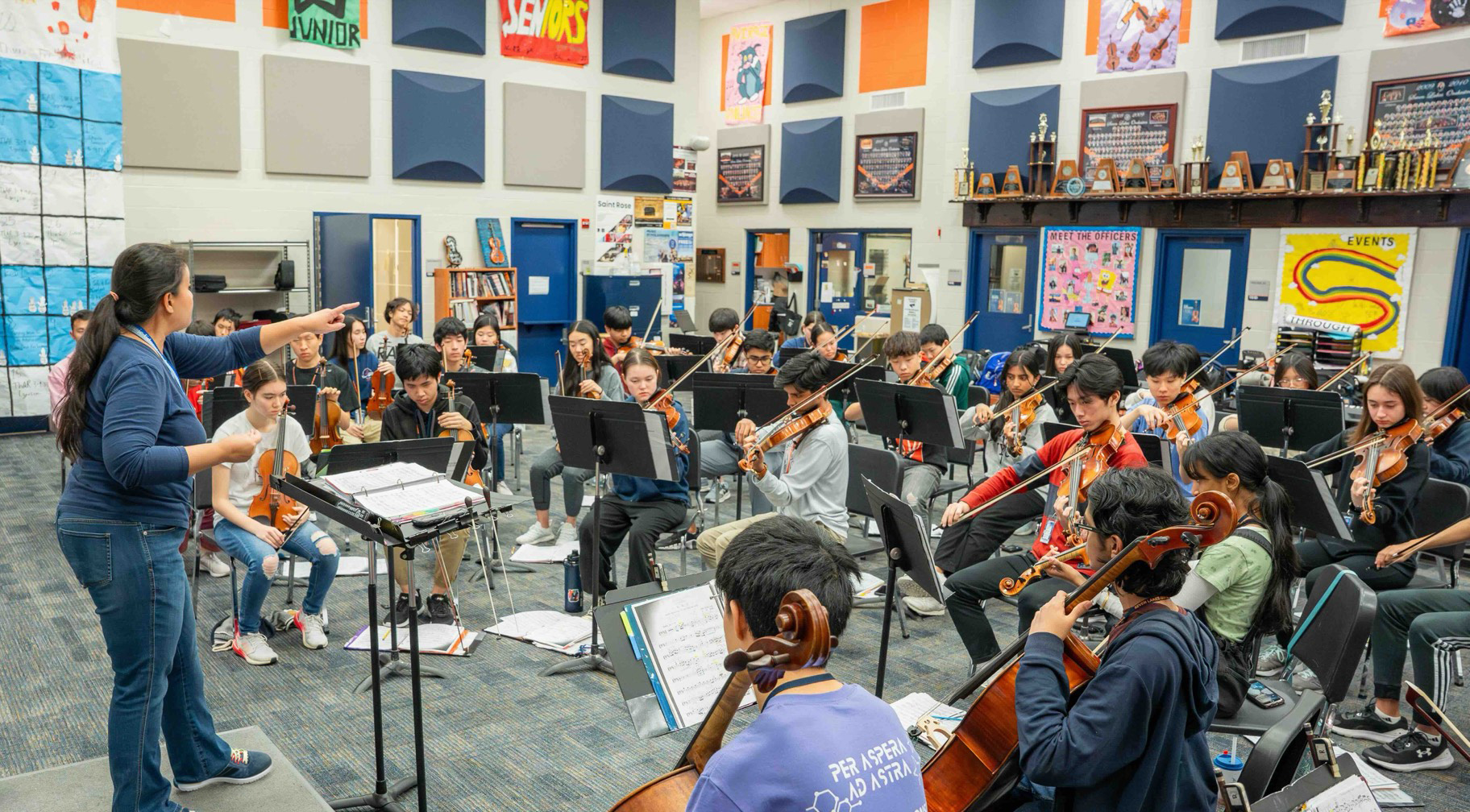 Orchestra director leading students in rehearsal